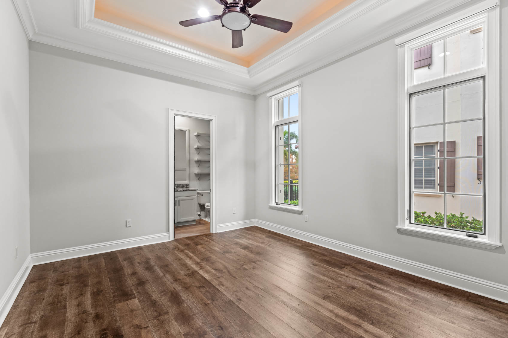 empty bedroom with wood floors and windows